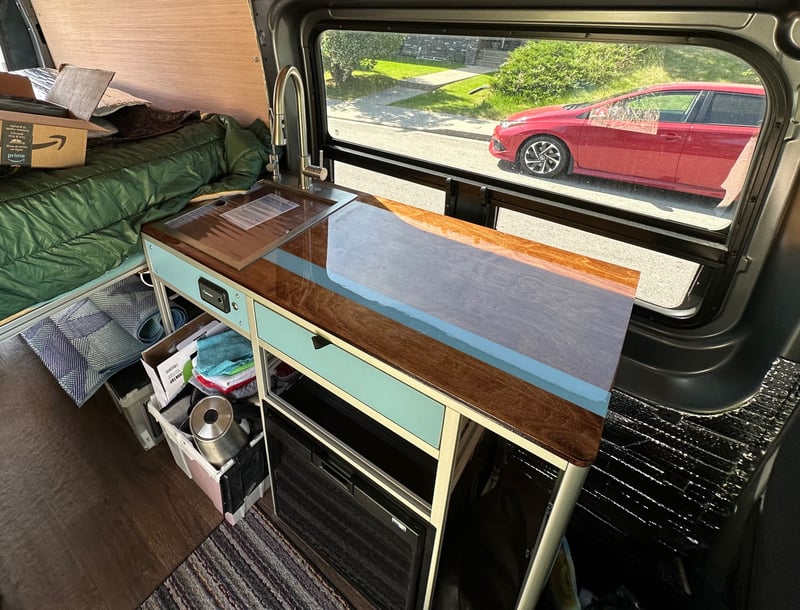 The van galley with sink, induction cooktop, and fridge
