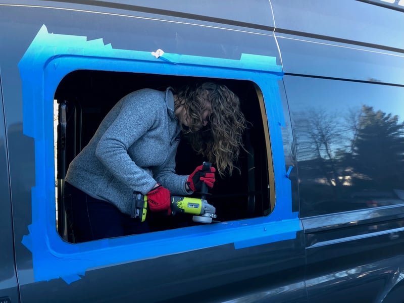 Taylor angle-grinding the window opening, sparks flying